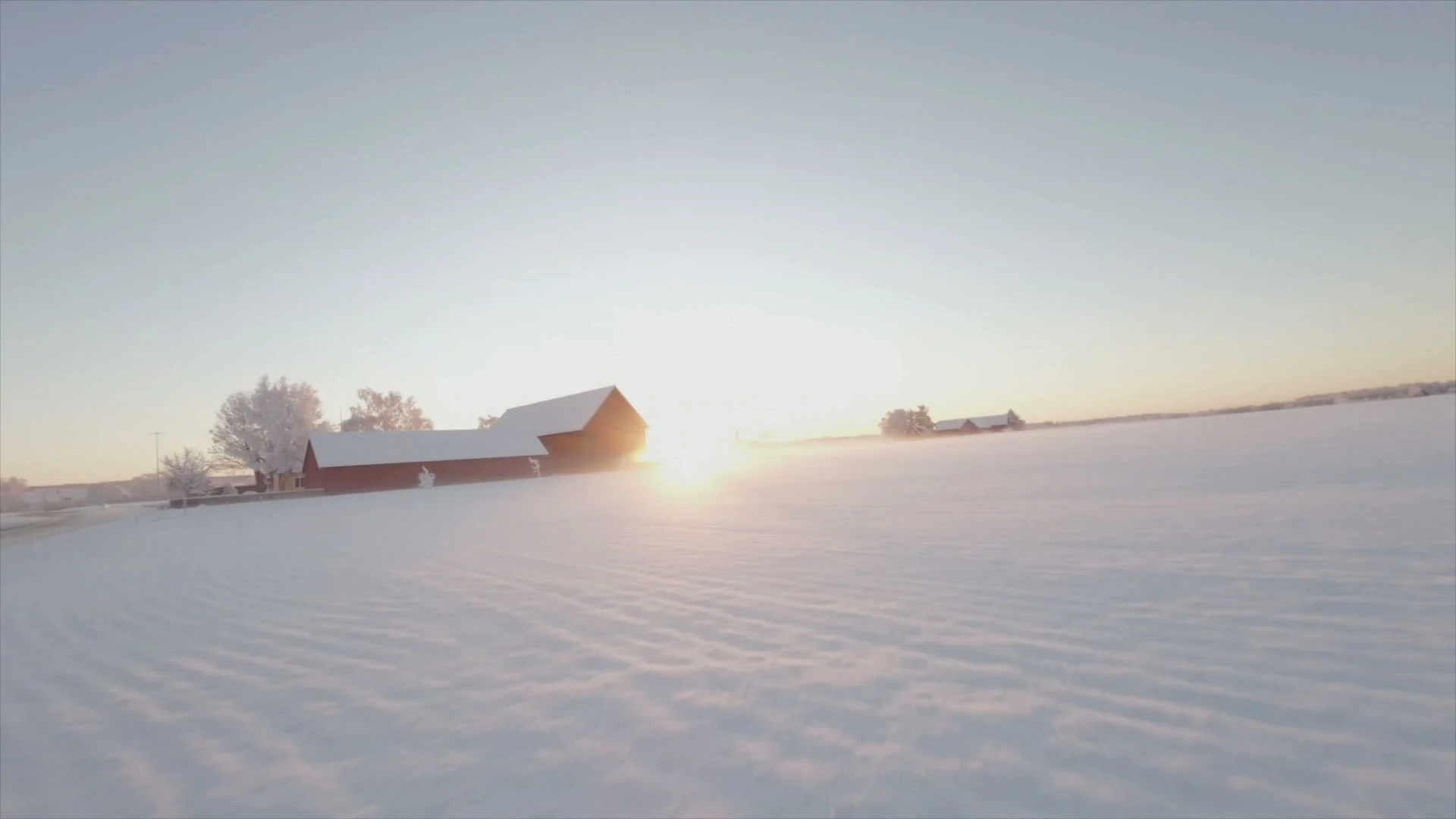 Snötäckt fält i soluppgång med röda gårdsbyggnader – FigFlows hero